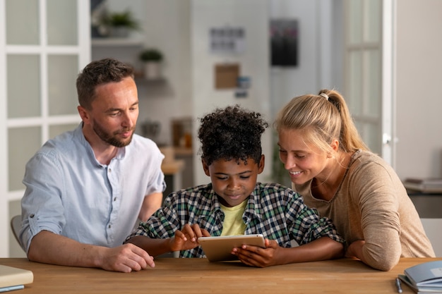 Front view parents and kid with tablet