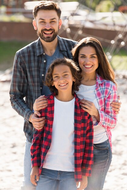 Front view of parents with child posing while outdoors