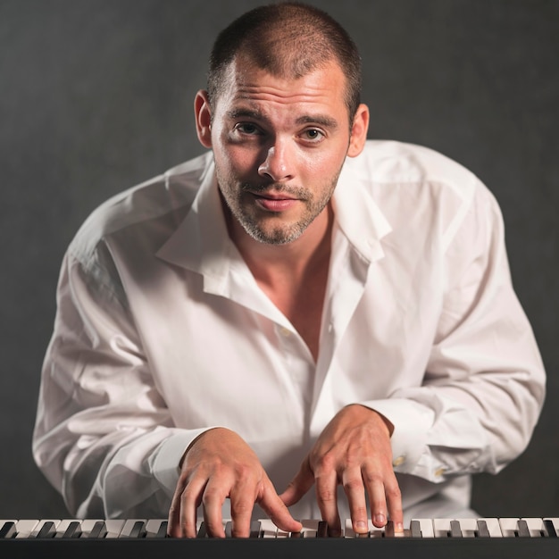 Free photo front view passionate man playing keyboards