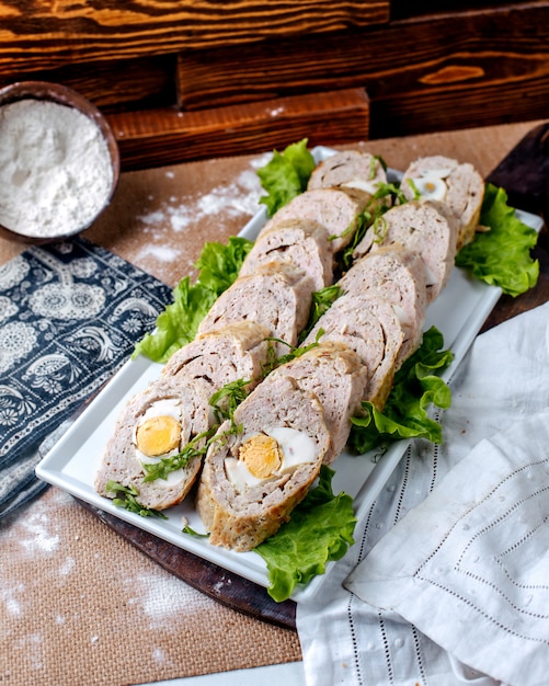 Free Photo front view pate rolls along with fresh green salad inside white plate on the brown floor