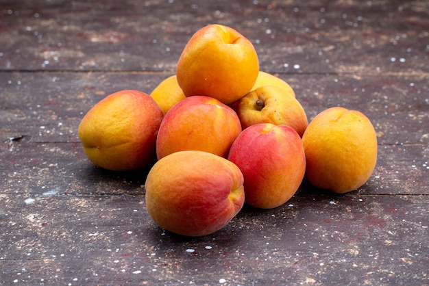 Free photo a front view  peaches mellow and juicy on the wooden desk fruit summer pulp