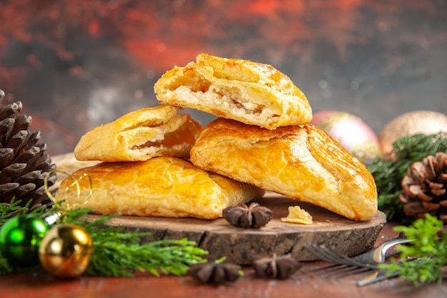 Front view penovani khachapuri on wood board pine tree branches and cones anises on dark red table