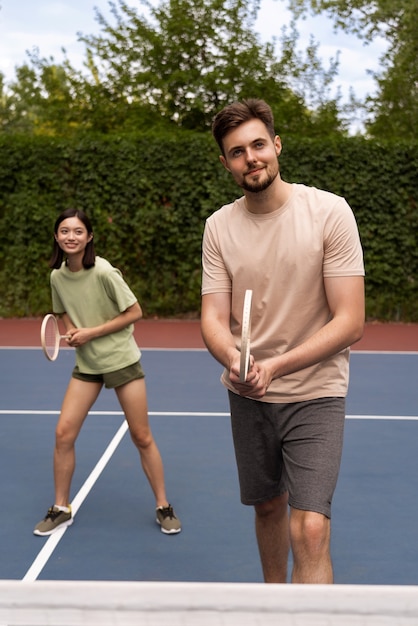 Front view people playing badminton