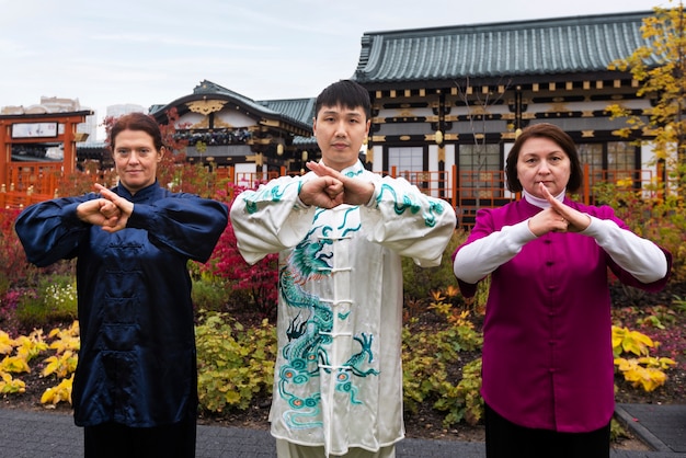 Free photo front view people practicing tai chi outside