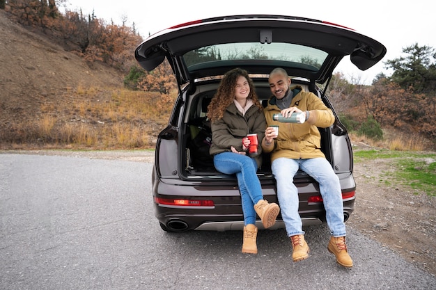 Front view people sitting in car trunk