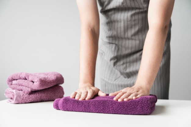 Front view person folding towels