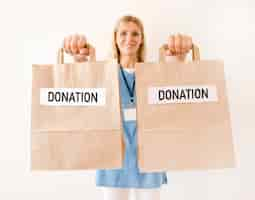 Free photo front view of person holding donation bags