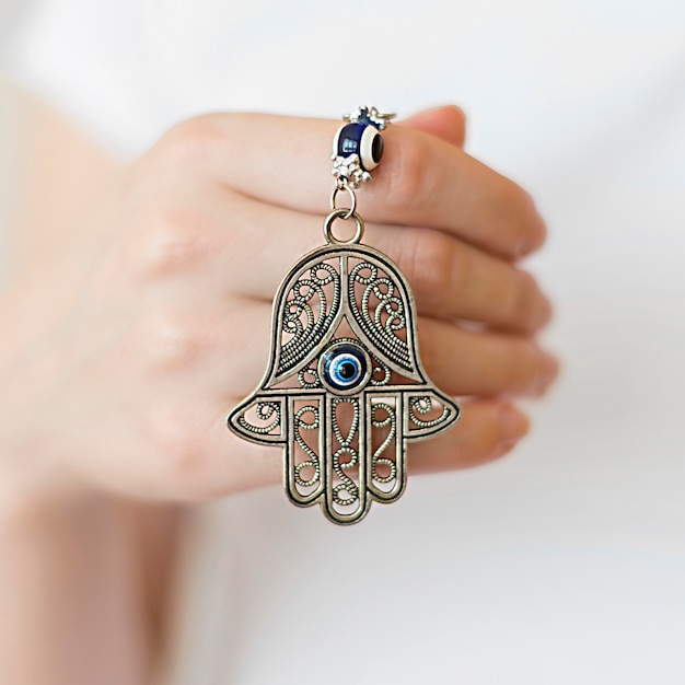 Free photo front view of person holding hamsa pendant