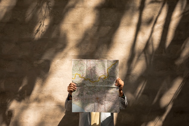 Free Photo front view person holding map over face