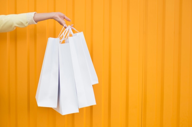 Free Photo front view person holding white shopping bags copy space