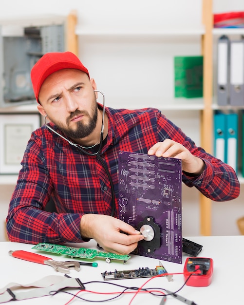 Free photo front view person repairing a motherboard