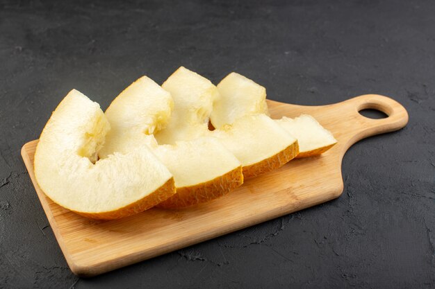 A front view pieced fresh melon mellow juicy and sweet lined on wooden desk