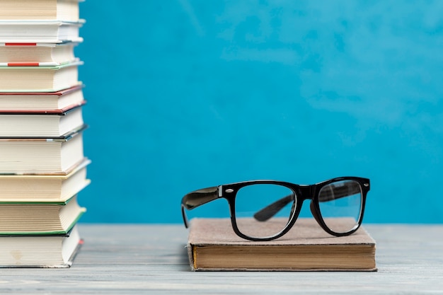 Front view pile of books with glasses