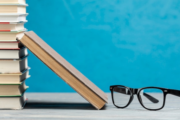 Free photo front view pile of books with glasses