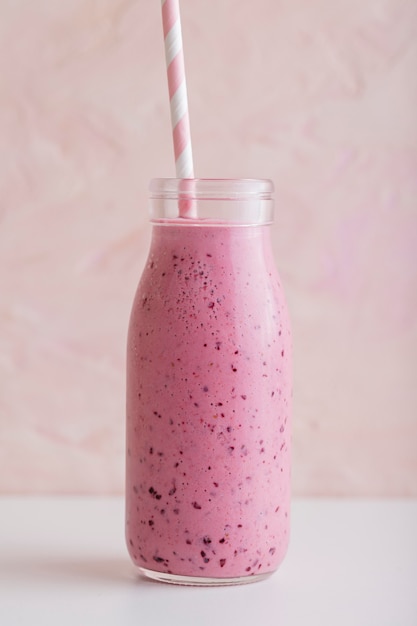 Front view pink smoothie bottle with straw