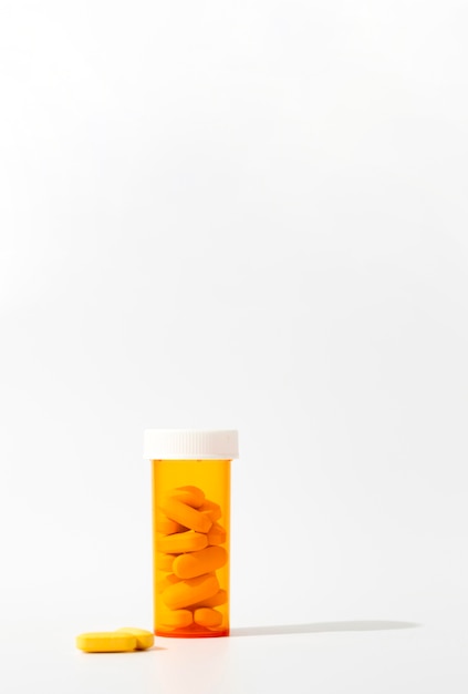 Free photo front view of plastic container with pills and copy space