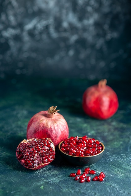 Front view pomegranate seeds bowl pomegranates on dark surface