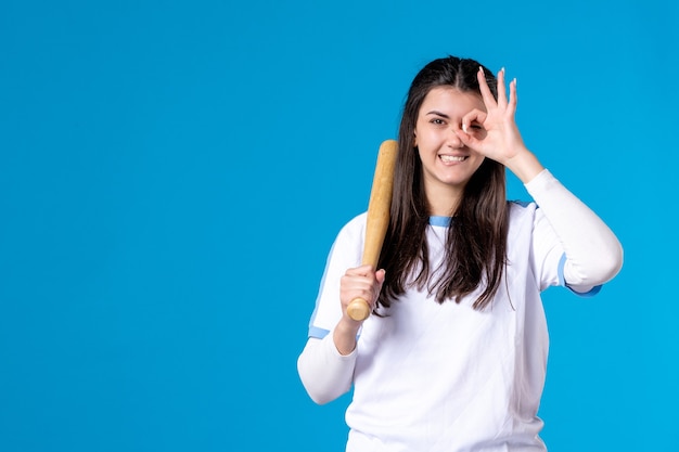 Front view posing young female with baseball bat on blue 