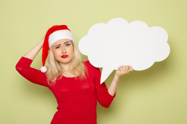 Front view pretty female holding cloud shaped white sign on green wall christmas snow holiday emotion new year