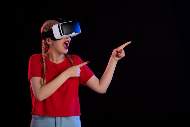 Front view of pretty female playing vr on dark  ultrasound game fantasy