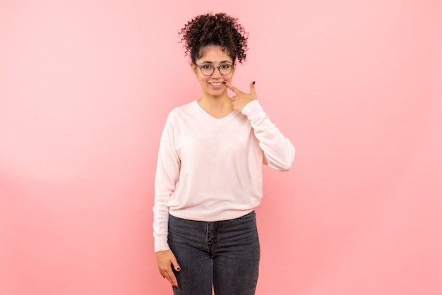 Front view of pretty female smiling on pink