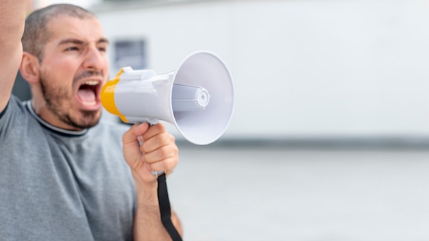 Front view protester shouting with megaphone