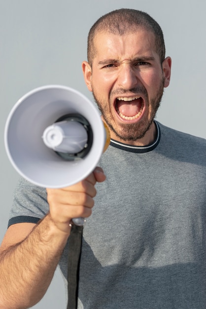 Free photo front view protester with megaphone shouting