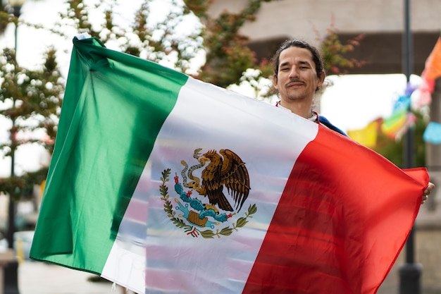 Free photo front view proud man holding mexican flag