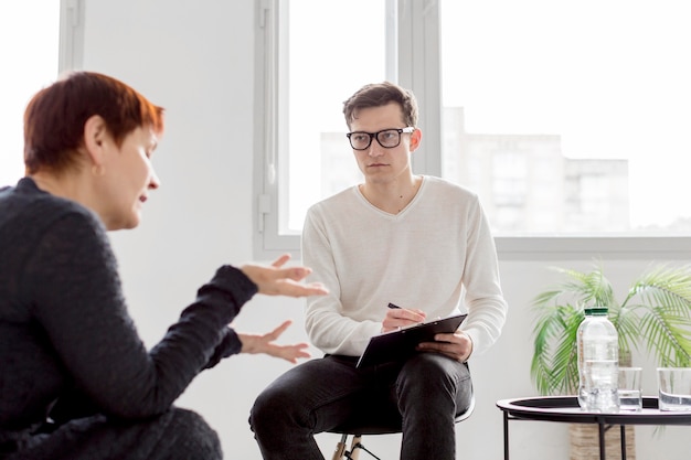 Free photo front view of psychologist consulting a patient