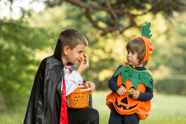 Free Photo front view of pumpkin and dracula halloween costumes