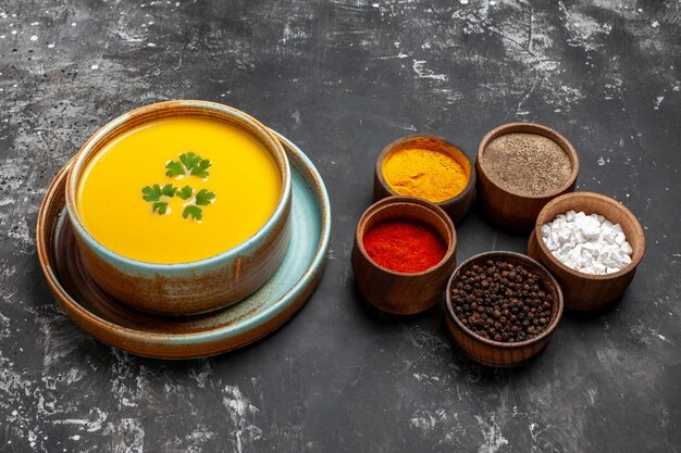 Front view pumpkin soup with seasonings on dark table 