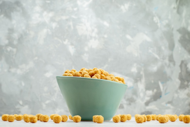 Free photo front view raw cereals yellow colored inside green plate on white, cereal breakfast cornflakes health