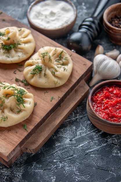 Free Photo front view raw little dumplings with meat and tomato sauce on a gray surface dough meal cake pie cuisine dish dinner meat cooking