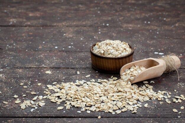 Front view raw oatmeal light colored all over the dark crackers snack bread dried meal useful health breakfast