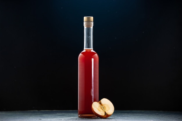 Front view red apple sauce in bottle on dark surface