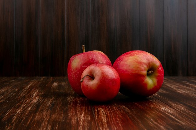 Front view red apples on a wooden background