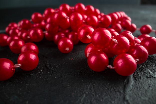 Free photo front view red necklace on dark background color photo fruit berry