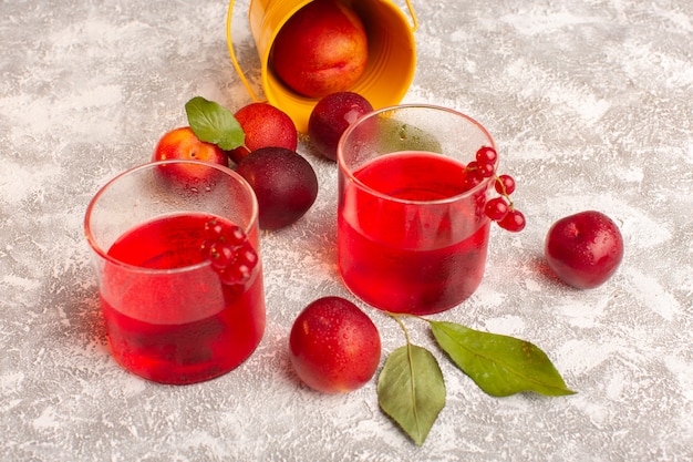 Free Photo front view red plum juice with fresh plums on bright fruit color juice drink