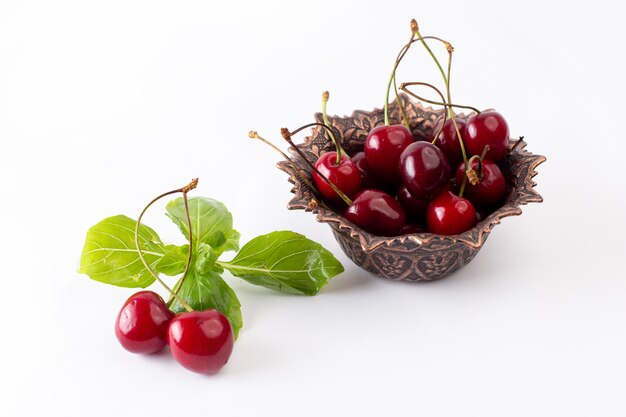 Front view red sour cherries inside brown plate on white