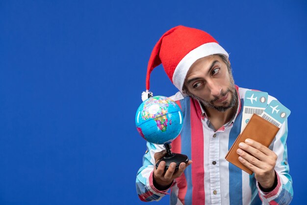 Front view regular male with tickets and globe on a blue wall emotion holiday new year