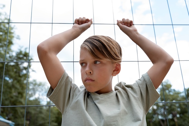 Free Photo front view sad boy near fence