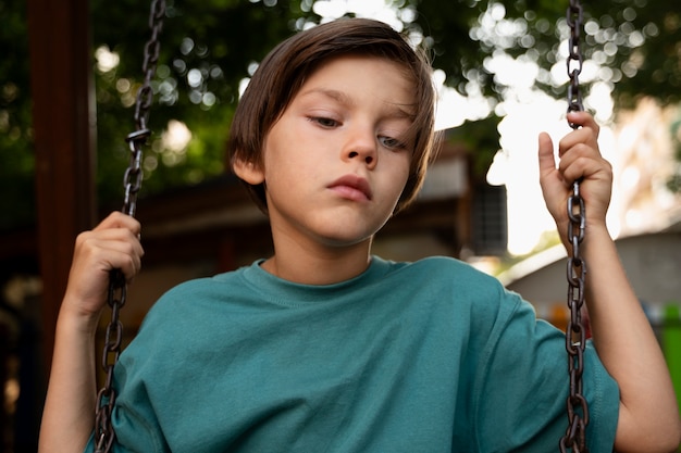 Front view sad kid on swing