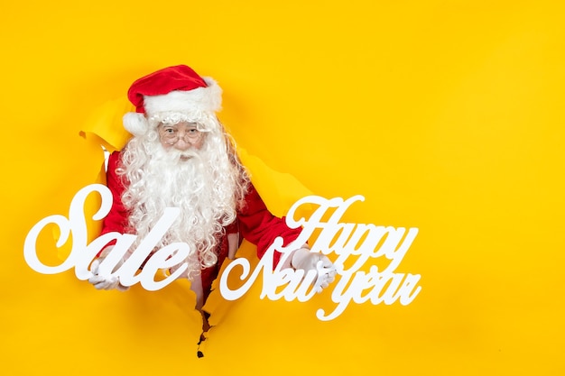 Free Photo front view santa claus holding sale and happy writings