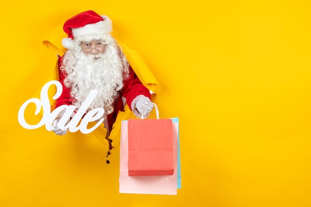 Free photo front view santa claus holding sale writing and packages