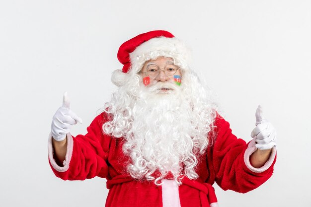 Front view of santa claus with azerbaijani and turkish flag paints on his face on a white wall