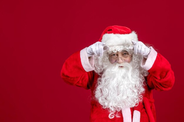 Front view santa claus with classic white bear and red clothes on a red