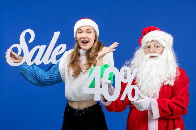 Free Photo front view santa claus with female holding sale writings on a blue holiday cold christmas new year snow