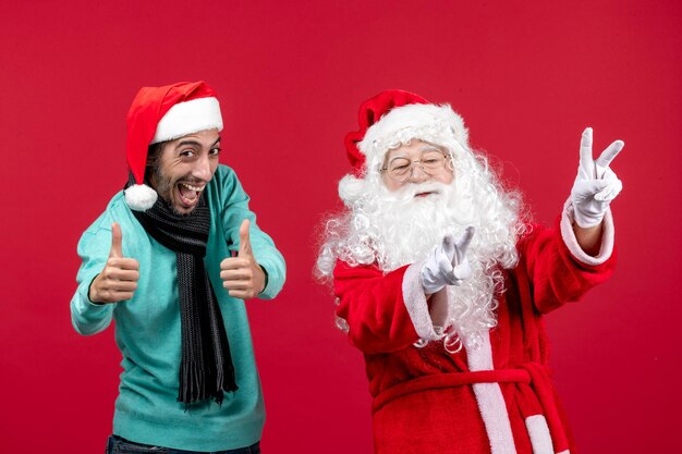 Front view santa claus with male just standing on red presents holiday christmas emotion