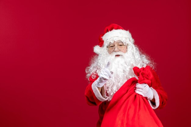 Front view santa claus with red bag full of presents on a red christmas