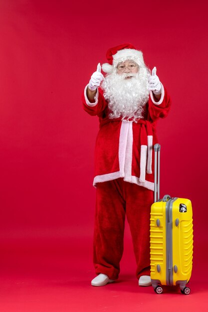 Free Photo front view of santa claus with yellow bag preparing for trip on red wall